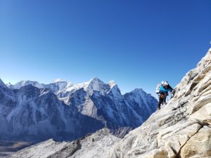 A climber traverses the granite rock of Ama Dablam