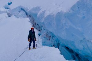 Climber looking into crevasse