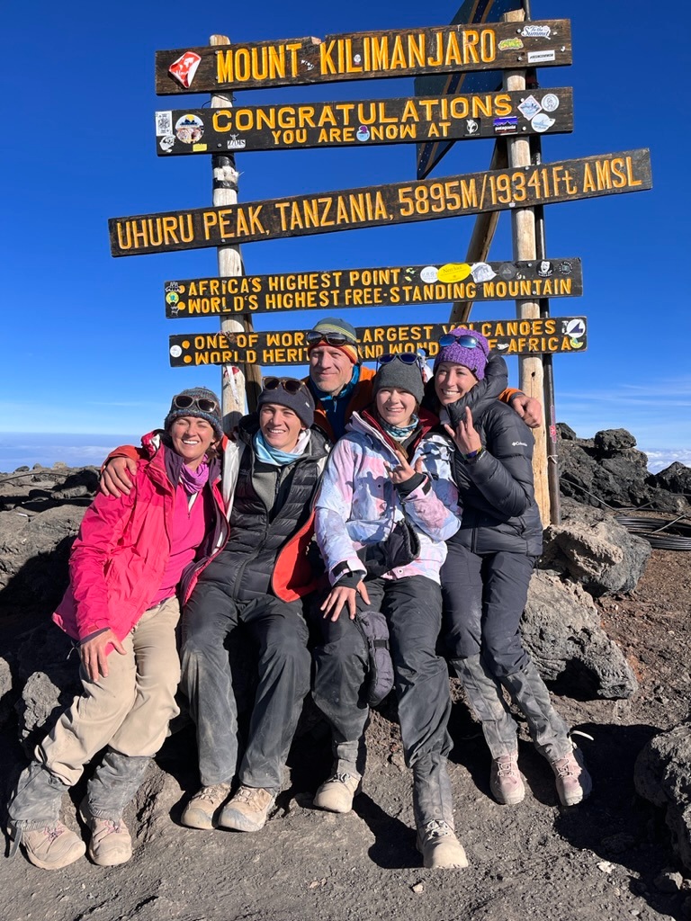 Clients on the summit of Kilimanjaro during a guided expedition with Alpenglow Expeditions.