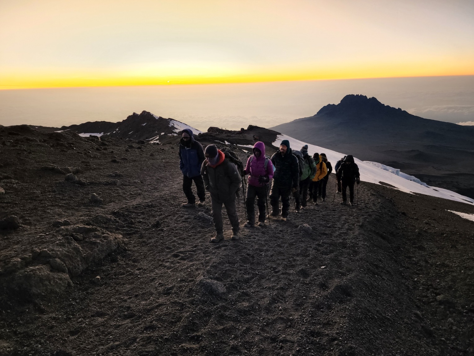 Clients hiking up Kilimanjaro at sunrise during a guided Kilimanjaro Expedition