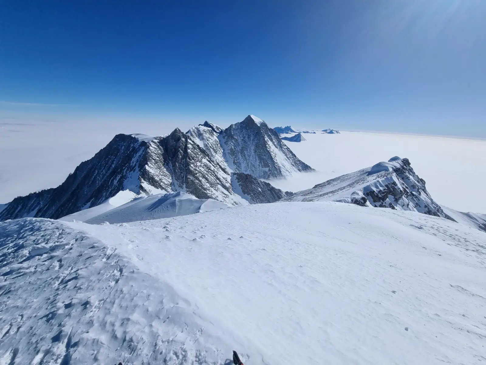 Vinson Massif stands high above the vast white landscape of Antarctica.