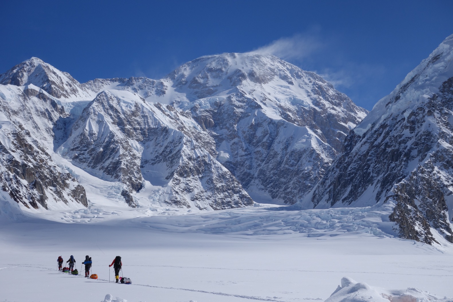 A group of clients skiing in with sleds during a guided Denali Expedition