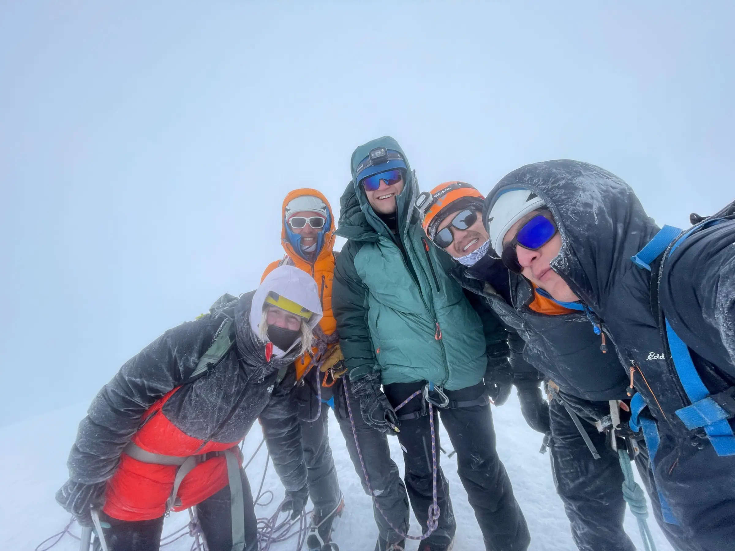 Intro to high-altitude mountaineering students on the summit of one of Ecuador's volcanoes with their professional mountain guide during Alpenglow Expeditions' Ecuador Climbing School.