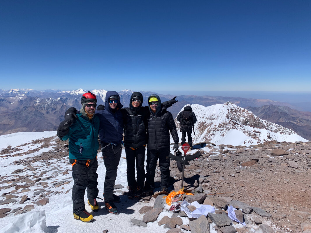 A group of mountaineers standing on the summit of Aconcagua