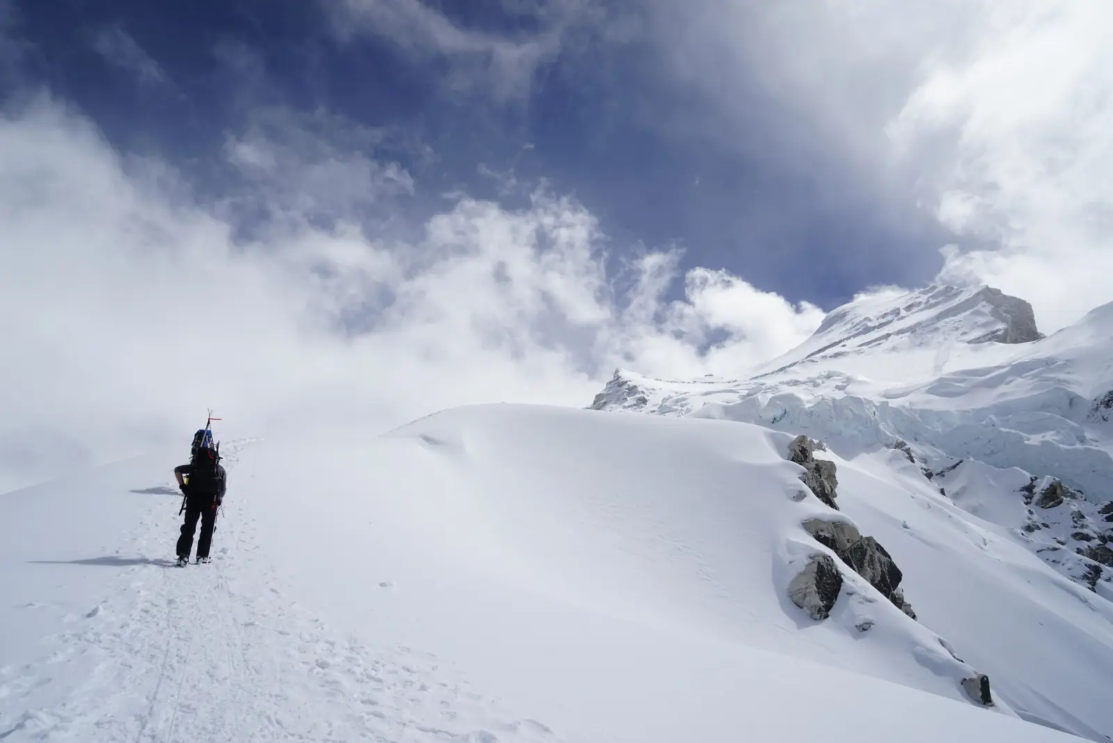 Client hiking up a glaciated slope during a Cho Oyu ski Expedition with Alpenglow Expeditions.