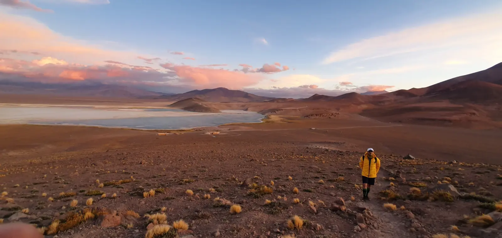 Client hiking during sunrise on a guided Ojos Del Salados Expedition