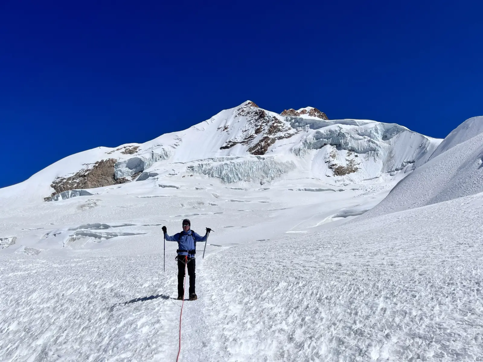 A mountaineer climbing up a glaciated slope in Bolivia