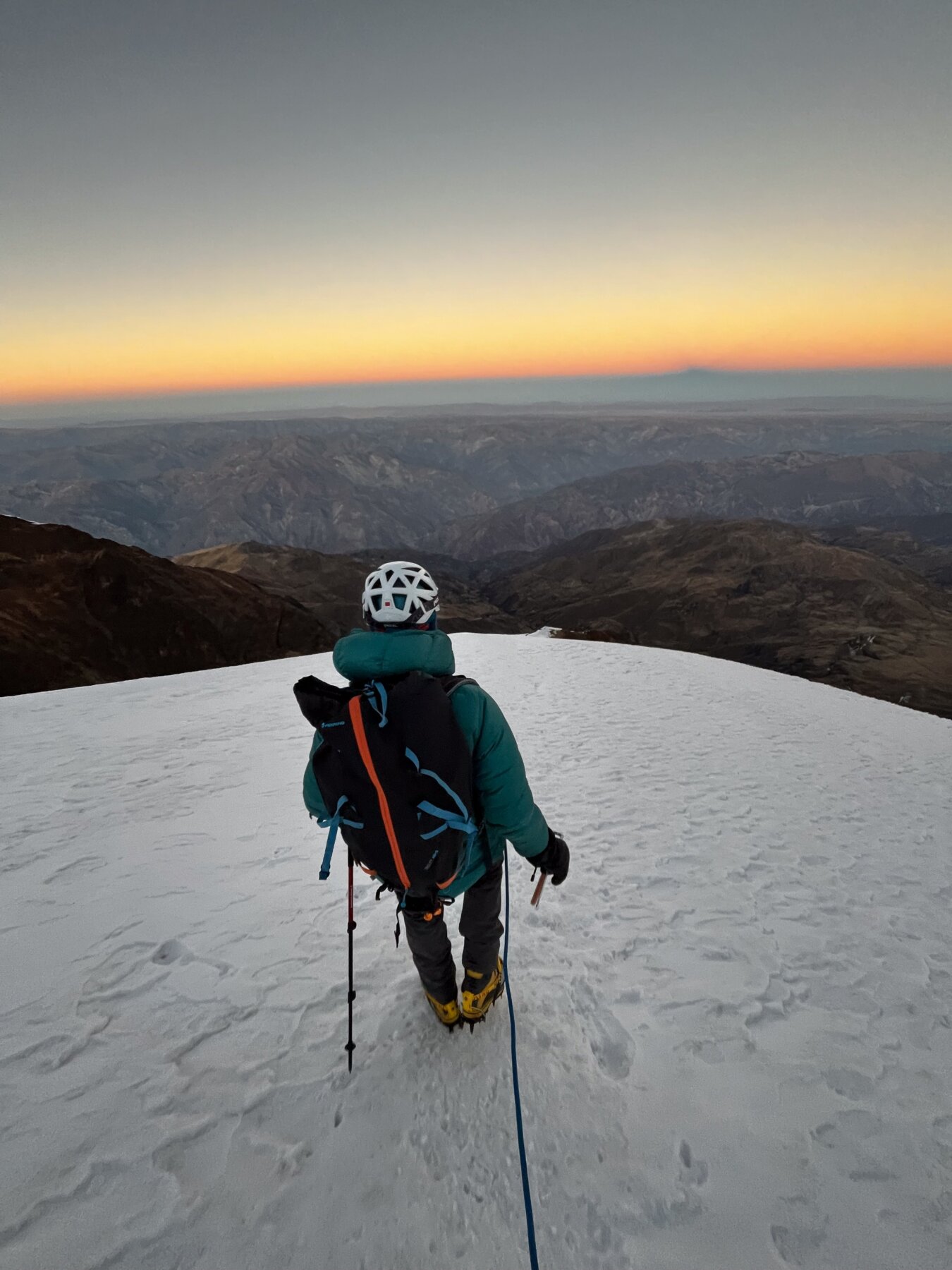 An alpine climber descending a glaciated slope during a guided Bolivia Expedition