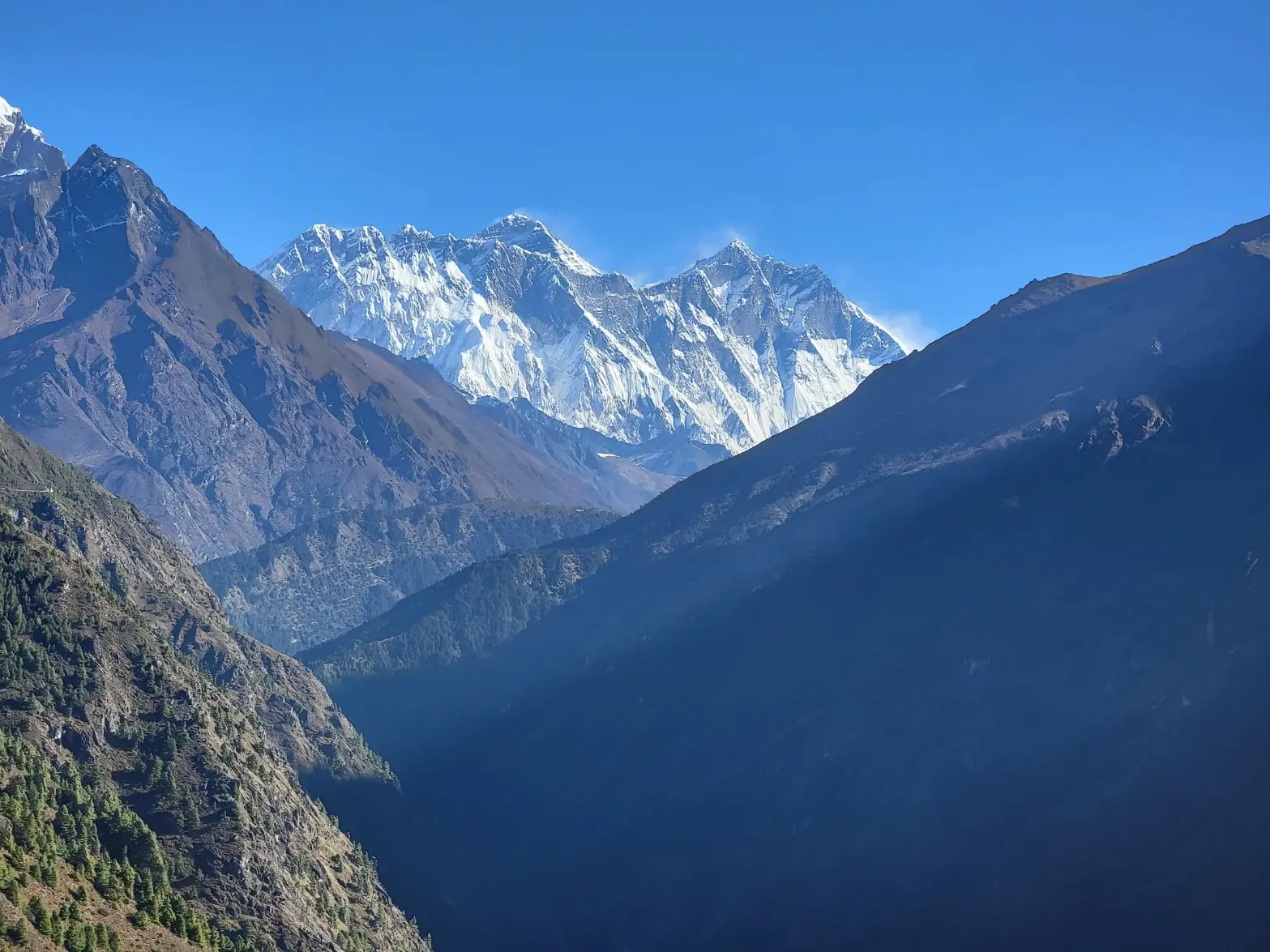 A valley on the Everest Base Camp trek route with the Himalayan mountain range in the distance, Nepal.