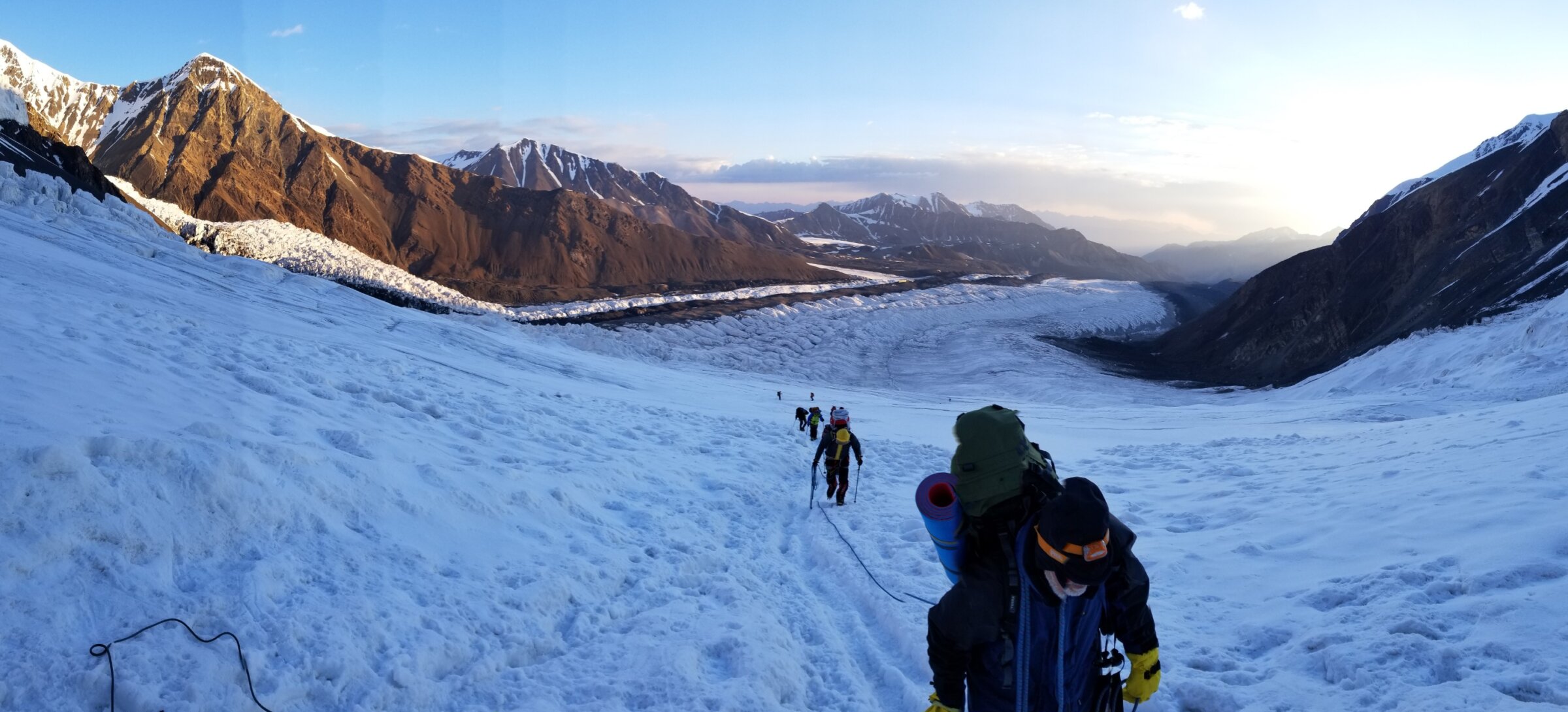 Clients climbing up a glaciated slope on a guided Peak Lenin Expedition with Alpenglow Expeditions.