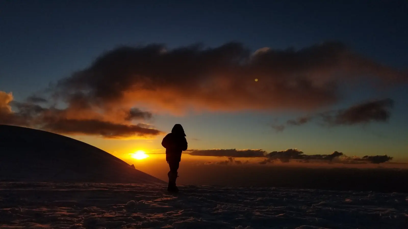 Client watching the sunset on Peak Lenin during a guided expedition with Alpenglow Expeditions.