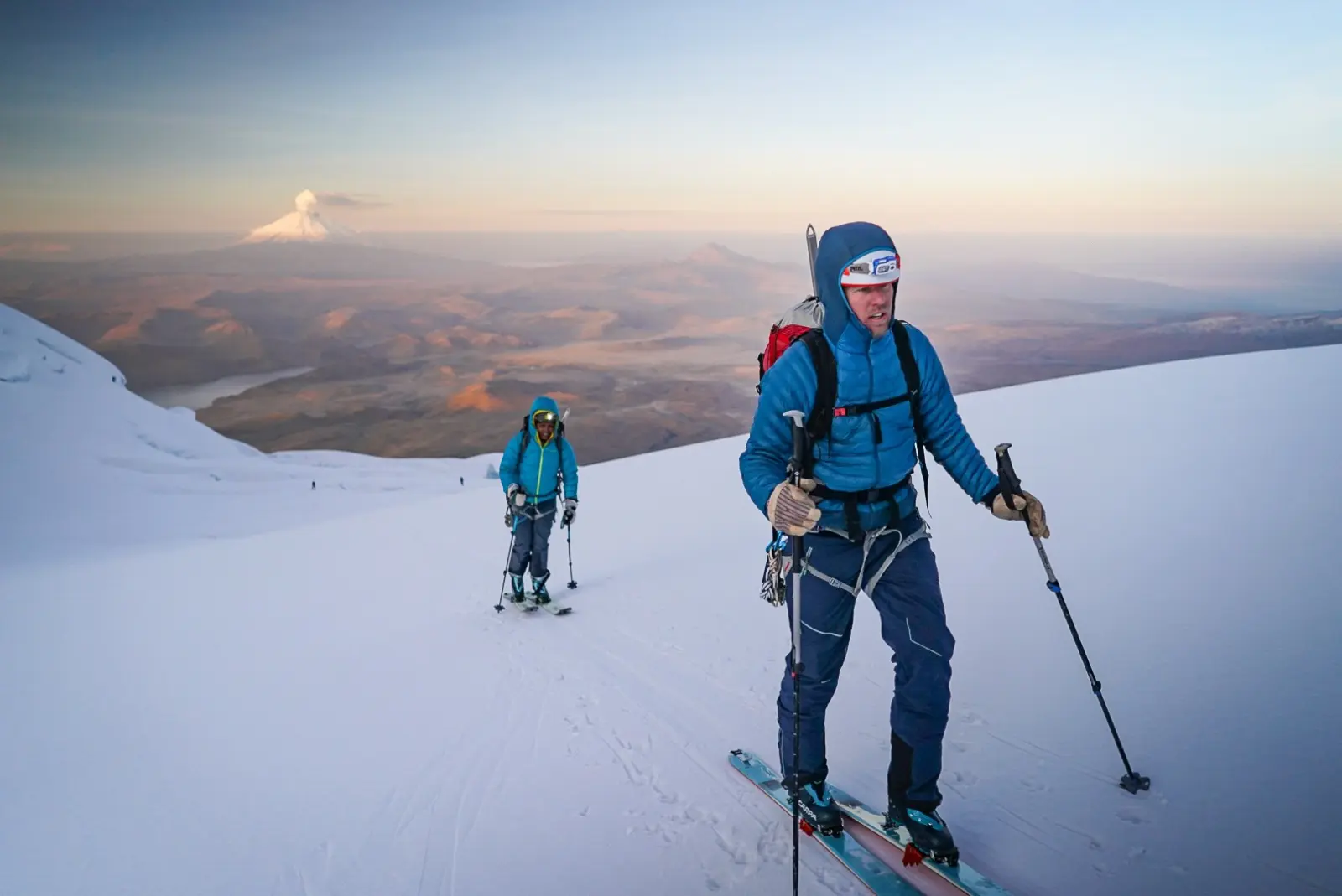 Two ski mountaineers on a snowy slope of a volcano in Ecuador with Alpenglow Expeditions' professionally guided ski mountaineering trip to Ecuador's Ring Of Fire.