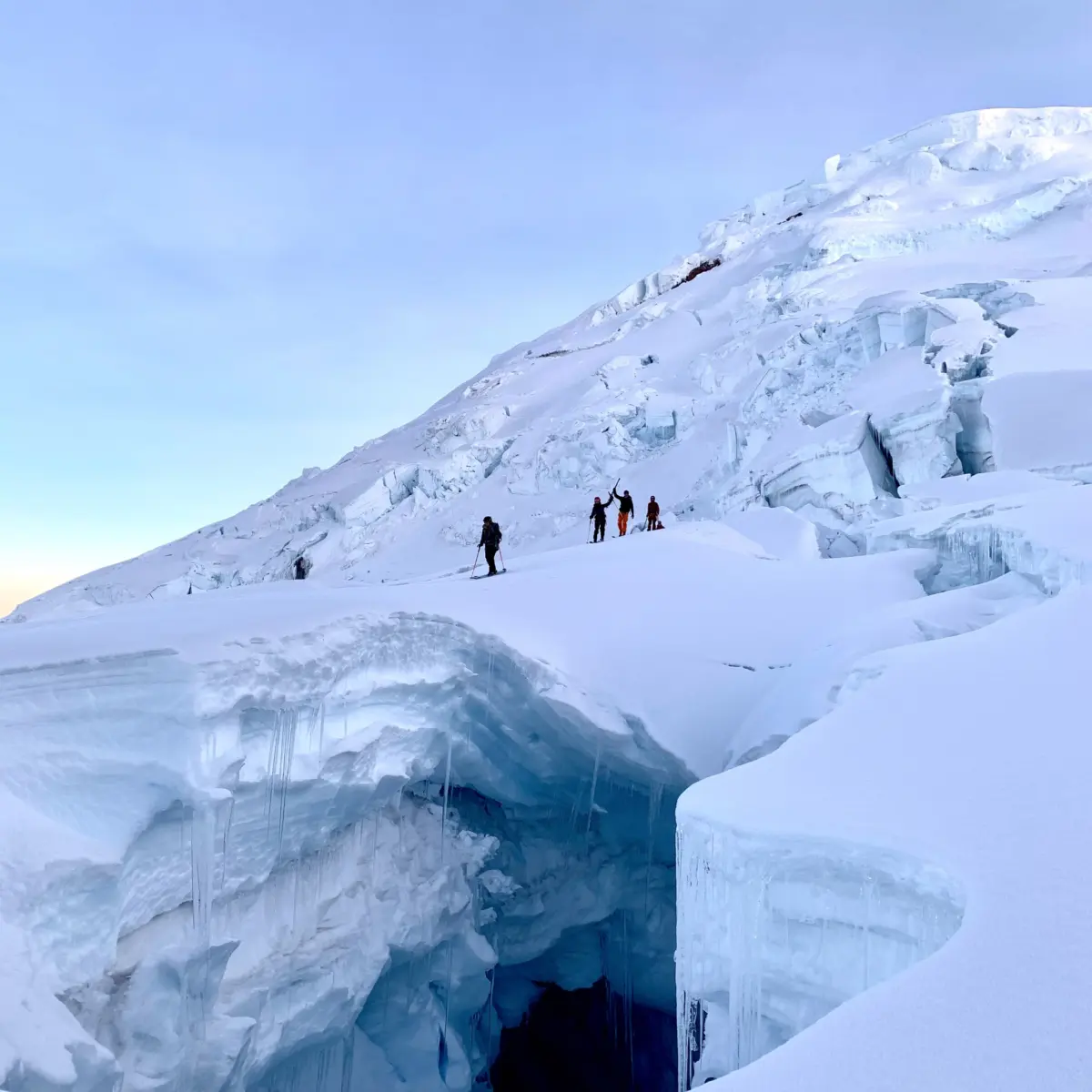 A group of ski mountaineers on a snowy slope of a volcano in Ecuador with Alpenglow Expeditions' professionally guided ski mountaineering trip to Ecuador's Ring Of Fire.