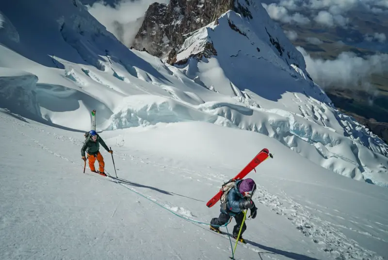 Two ski mountaineers on a snowy slope of a volcano in Ecuador with Alpenglow Expeditions' professionally guided ski mountaineering trip to Ecuador's Ring Of Fire.
