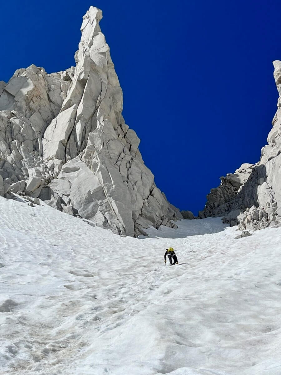 Client alpine climbing in the high sierra with professional mountain guides