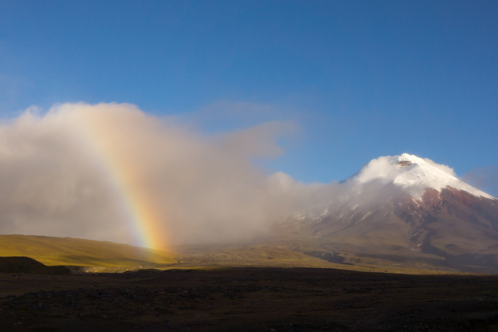 A rainbow in front of Cotopaxi during a guided expedition to climb Cotopaxi with Alpenglow Expeditions.