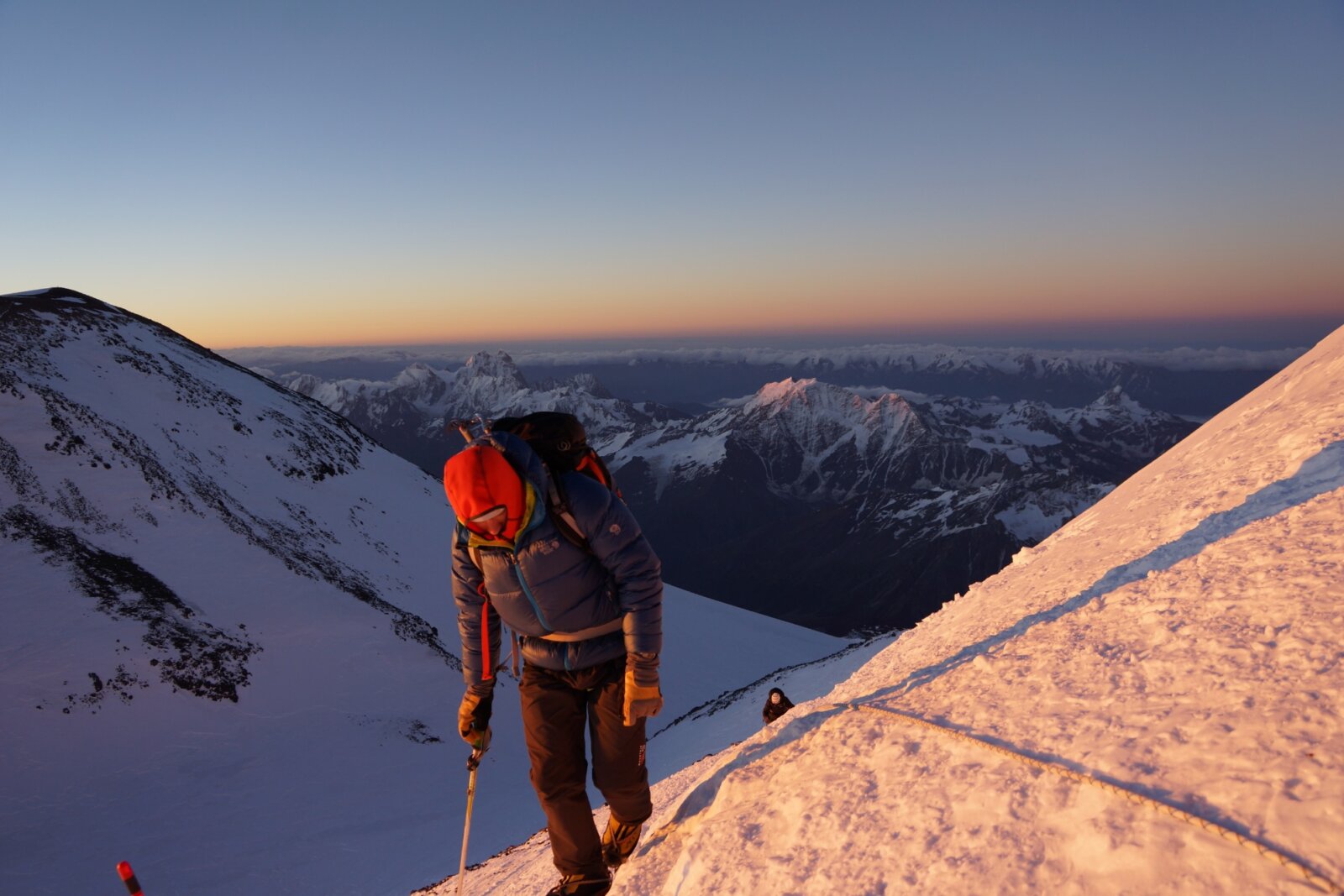 A guide climbing up Mount Elbrus at sunrise during a guided Expedition