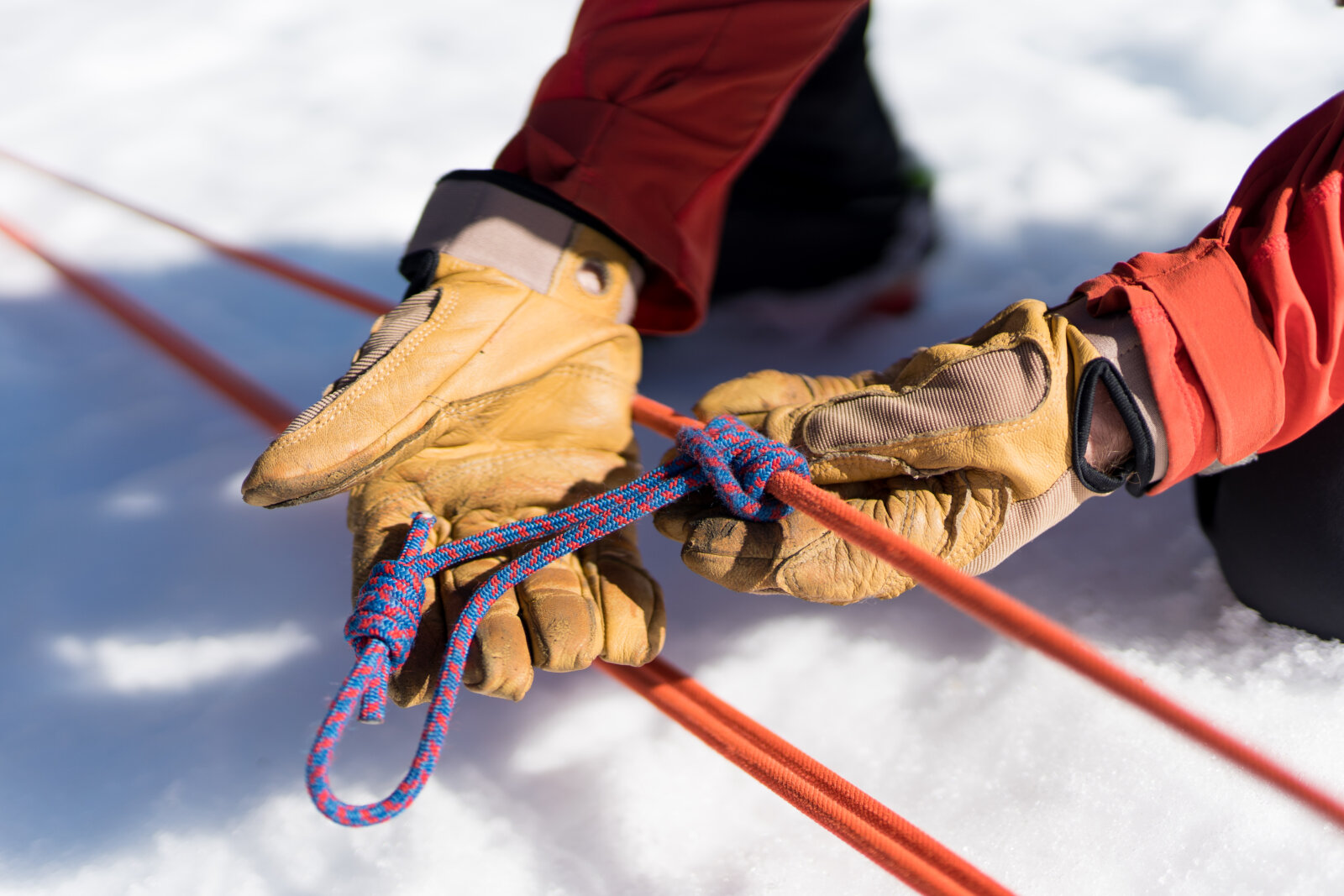 Guide shows rope skills during an Intro to Mountaineering course near Lake Tahoe in the Sierra Nevada mountains with Alpenglow Expeditions' professional mountain guides.