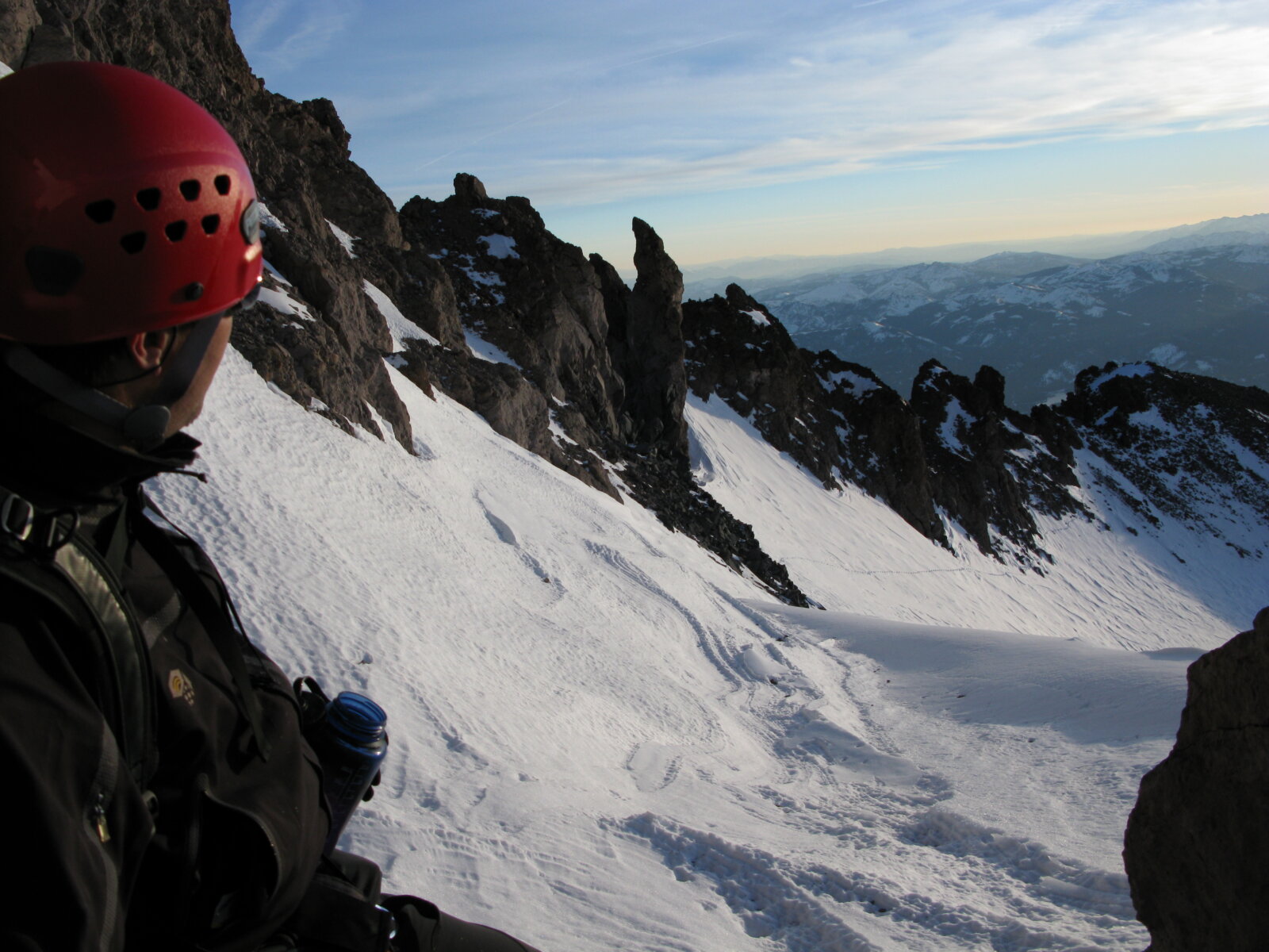 A mountaineering client looks out at Avalanche Gulch on Mount Shasta during a guided trip with Alpenglow Expeditions