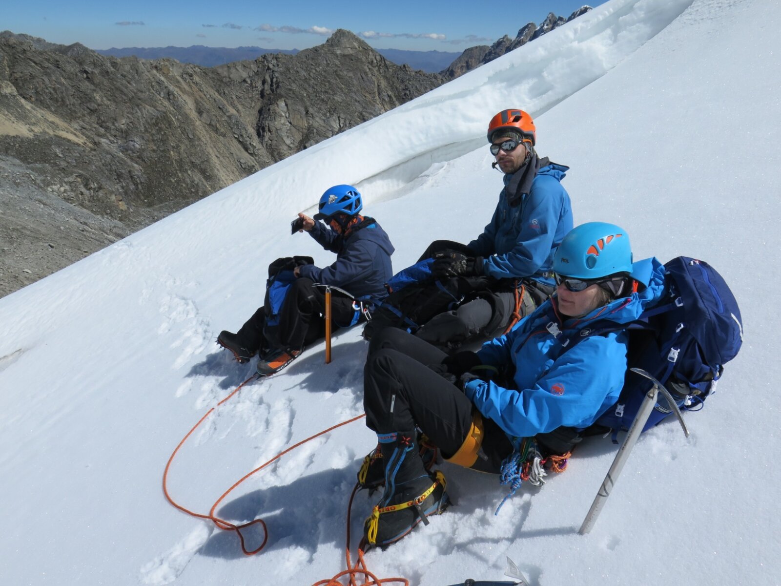 Climbers sitting on a glacier eating lunch in Peru.