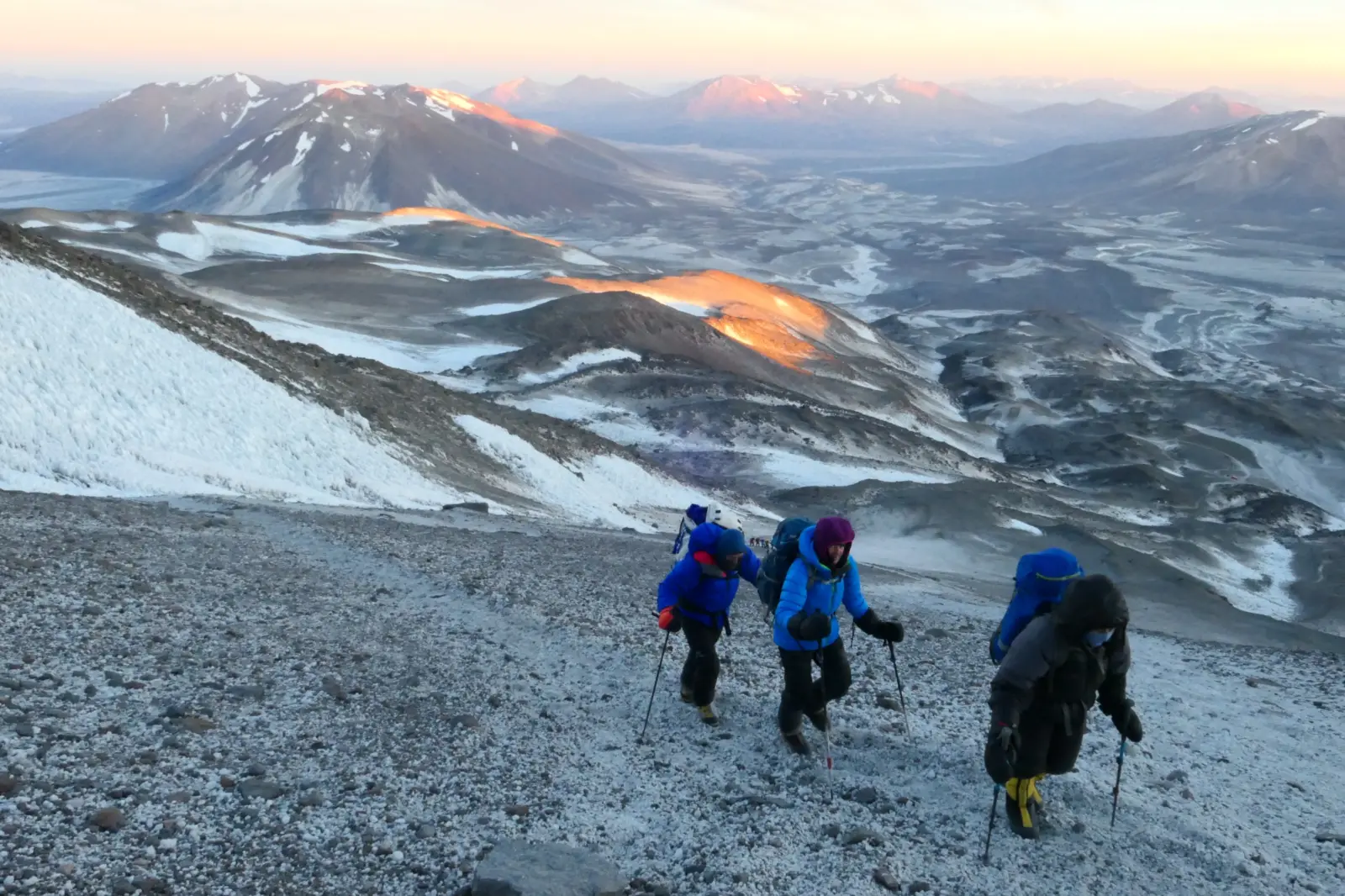 A group of clients hiking up Ojos Del Salados during sunrise