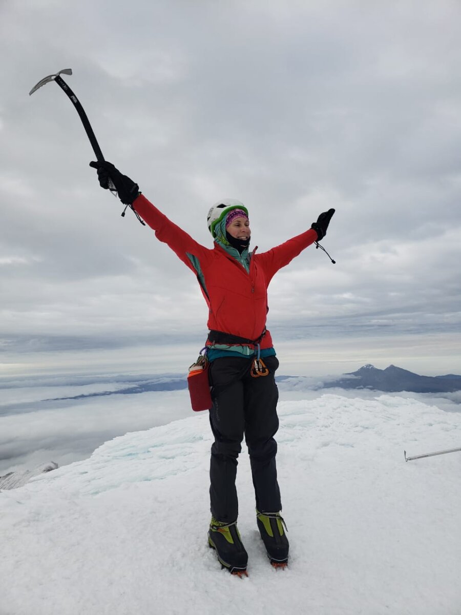 Female climber standing on the Summit of an Ecuadorian volcano during Alpenglow Expeditions' Women's Ecuador Climbing School.
