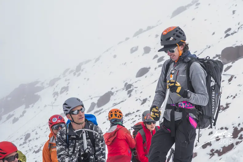 A mountaineer using an ice axe on the Cotopaxi glacier in Ecuador during an Alpenglow Expeditions high-altitude mountaineering course