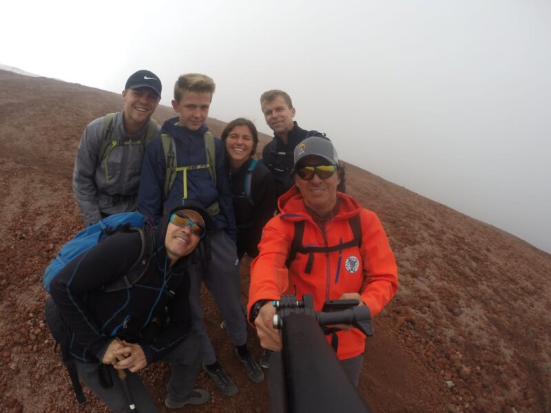 A climbing team and their guide sit on the slopes of Cotopaxi while acclimatizing.