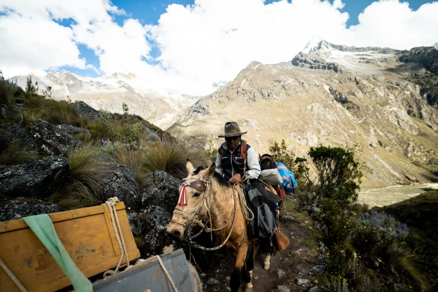 Porters carrying expedition packs along the Santa Cruz Trek trail through the Cordillera Blanca in Peru