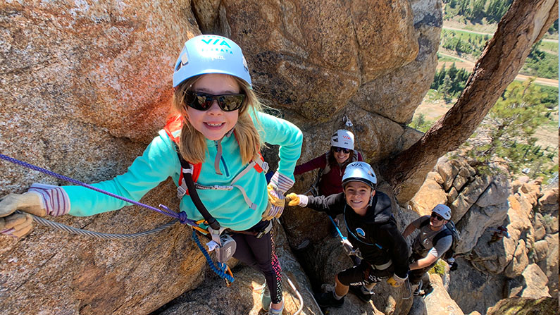 A family with young kids climbs on the Tahoe Via Ferrata guided by Alpenglow Expeditions.