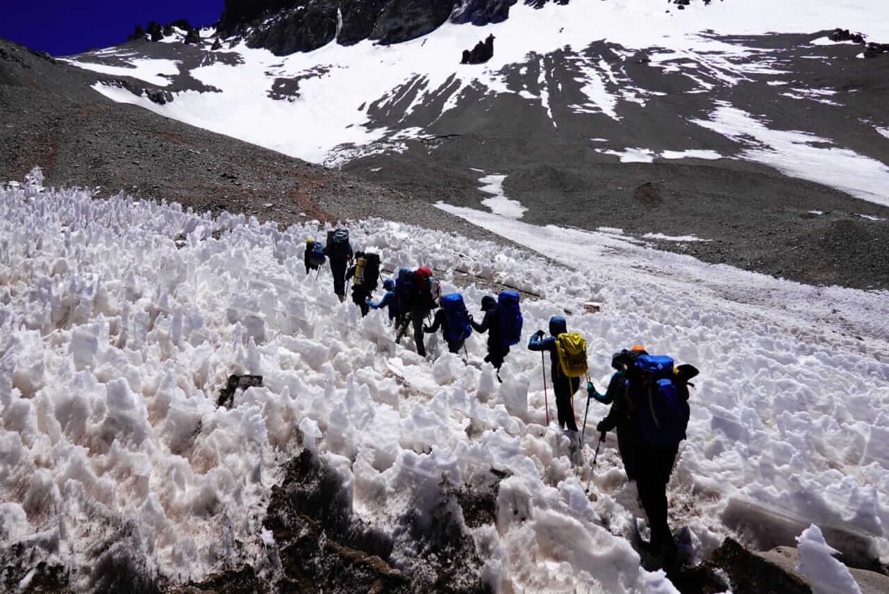 A group of climbers on an Alpenglow Expedition hikes through penitentes on Aconcagua as they move towards Camp 1.