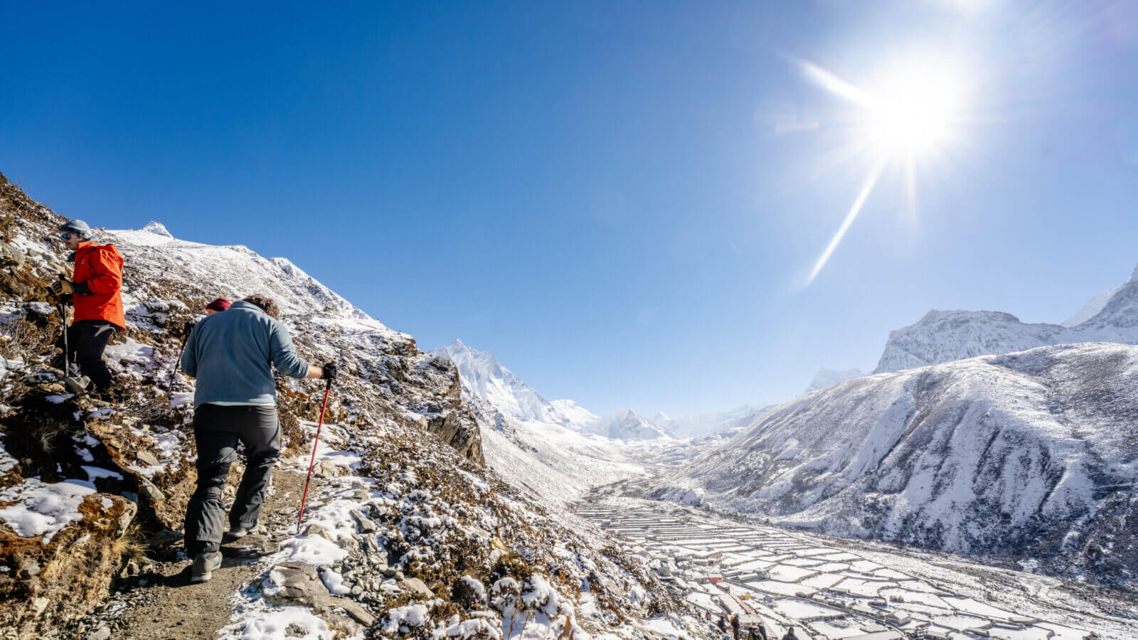 Two people climb a hill while trekking in the Khumbu.