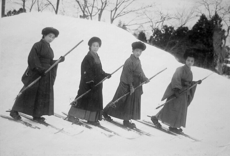 a black and white photo of four Japanese women in the early days of skiing in Japan