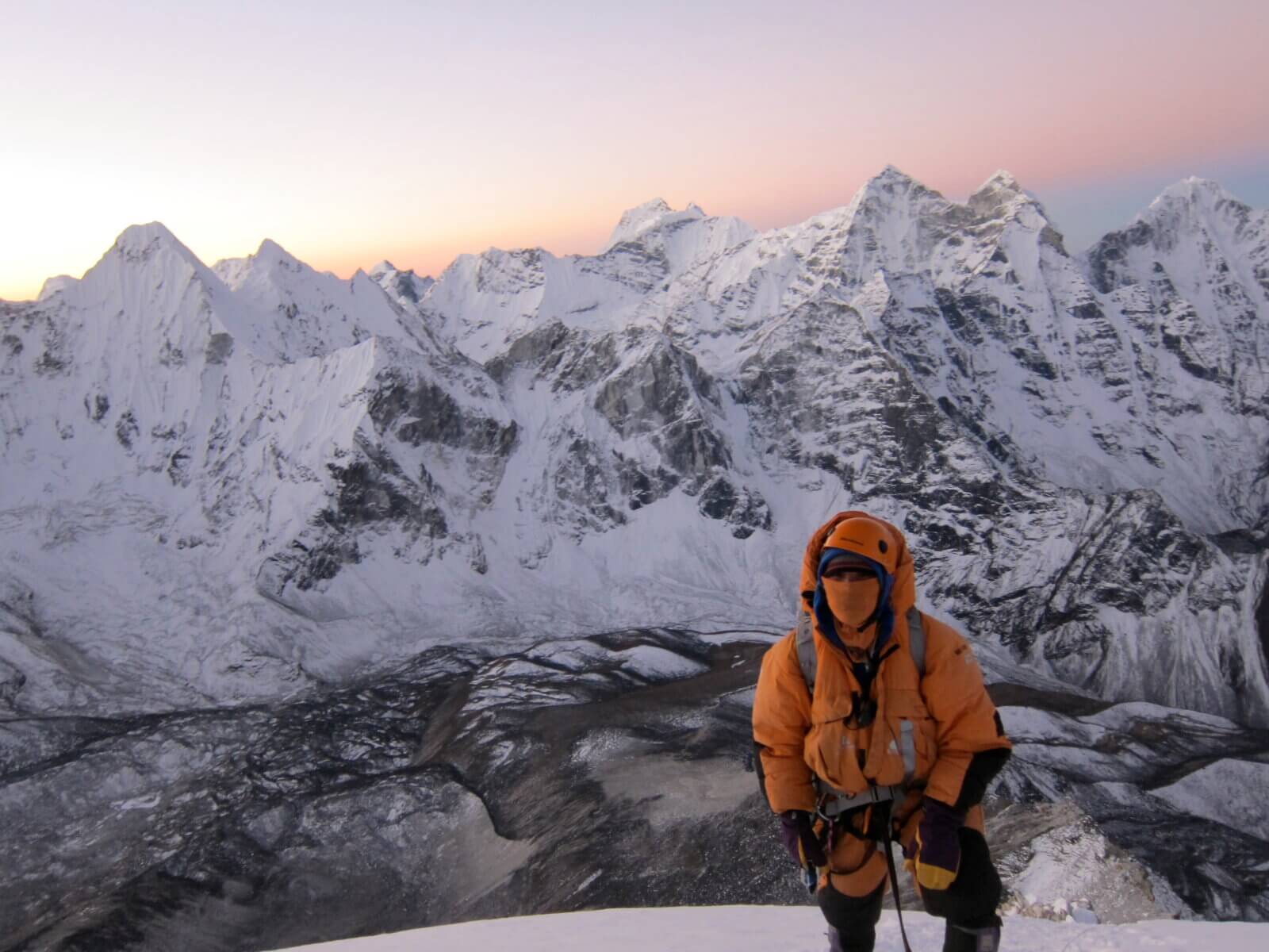 Climber on Everest at dawn during an Alpenglow Expeditions guided climb.