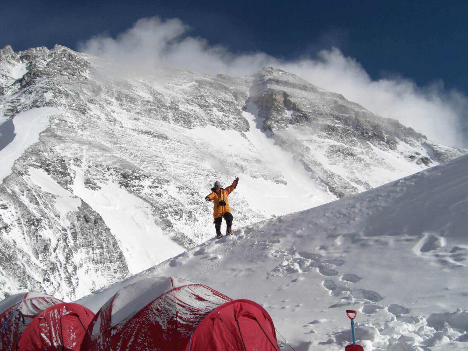 A client stands in from of Everest at North Col Camp during an Alpenglow Expeditions trip.