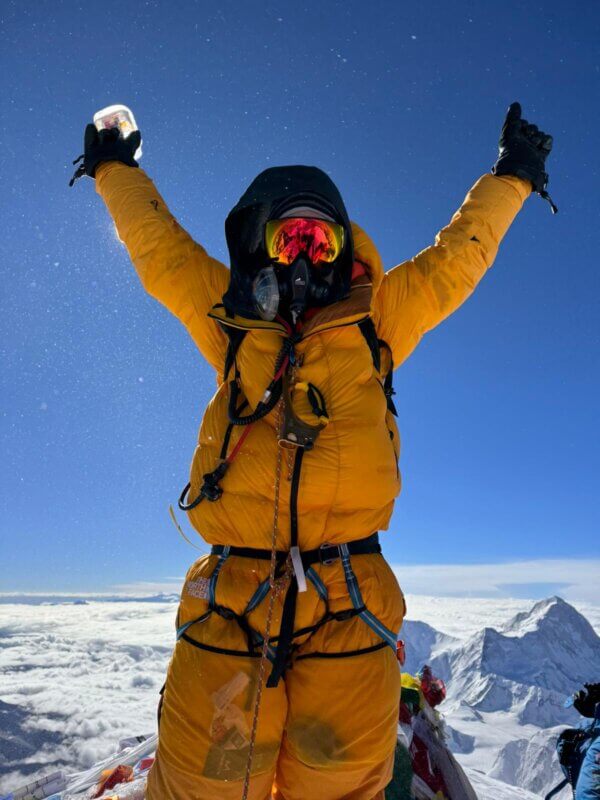 Graham Cooper standing on the summit of Mount Everest in 2024 with Alpenglow Expeditions team.