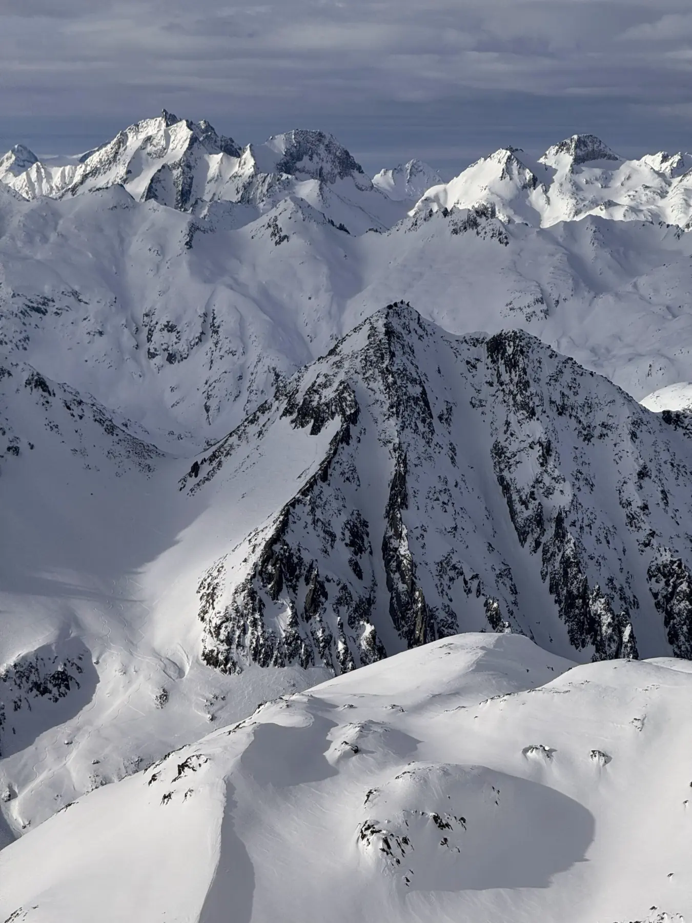 Skiers on a snow-covered alpine pass in Andermatt, Switzerland during an Alpenglow Expeditions guided ski adventure