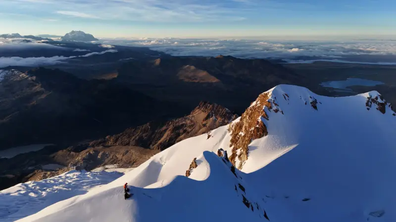 Two climbers at the summit of mountain in Bolivia.